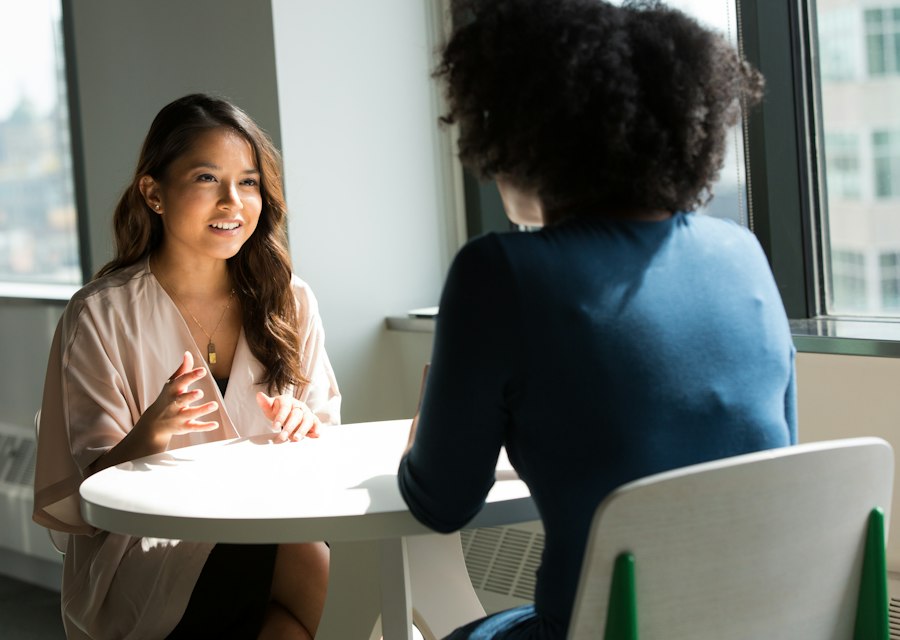 Two colleagues talking across a table during an interview
